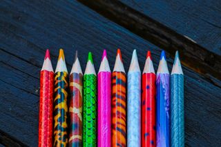 Colored pencils on an open texture table. Set of colored pencils on the background of the table