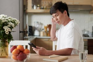 Man Reading a content syndication Article on Smartphone