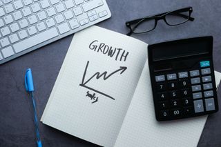 The word growth written on a notebook next to a calculator | How to Track your SEO Success with HubSpot Analytics