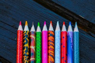 Colored pencils on an open texture table. Set of colored pencils on the background of the table